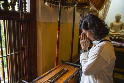 Buddhist worshiper donating at the temple of the holy tooth relic