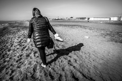 Rear view of woman walking on beach