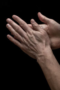 Close-up of hands over black background