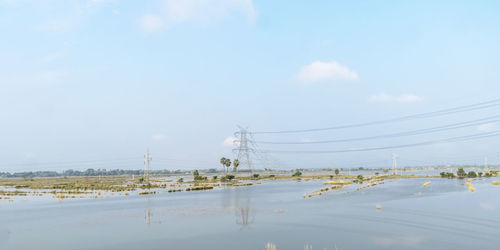 Electricity pylon on land against sky