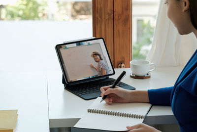 Midsection of woman using laptop at office