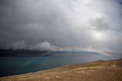 Scenic view of rainbow over land against sky