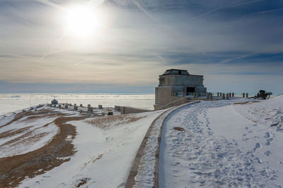 Scenic view of snow covered beach against sky