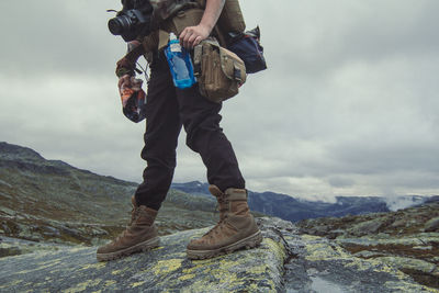 Courageous tourist on rock at highland scenic photography