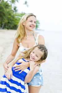 Happy mother and daughter at beach