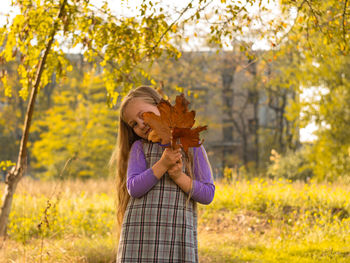 Close-up of girl holding autumn leaves