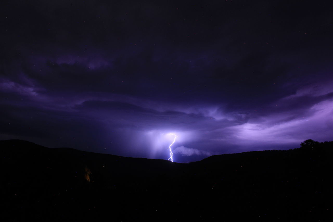 lightning, power in nature, storm, cloud, thunderstorm, sky, night, beauty in nature, thunder, dramatic sky, darkness, environment, storm cloud, warning sign, mountain, scenics - nature, nature, sign, purple, forked lightning, no people, communication, dark, silhouette, awe, outdoors, landscape, illuminated, atmospheric mood, overcast