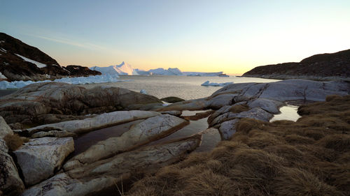 Scenic view of sea and mountains against clear sky