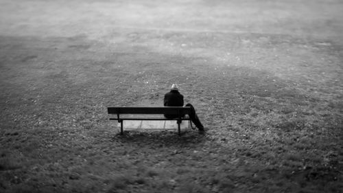 Rear view of man sitting on bench in park