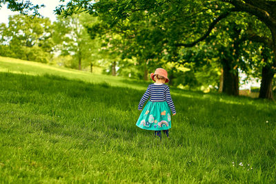 Rear view of girl standing on grassy land