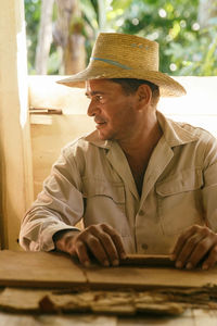 Portrait of man wearing hat sitting outdoors