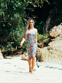 Portrait of young trans woman standing at beach