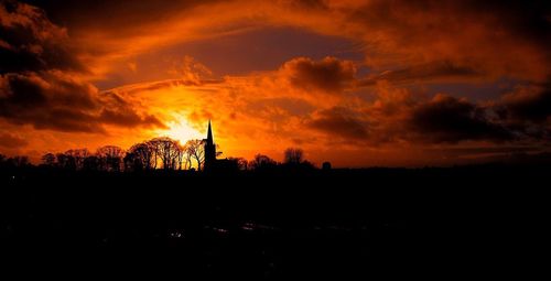Silhouette of landscape against cloudy sky