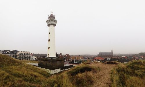 Lighthouse on landscape against clear sky