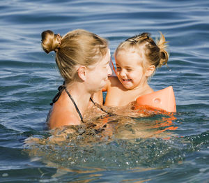 Rear view of women swimming in water