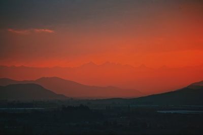 Scenic view of silhouette mountains against romantic sky at sunset