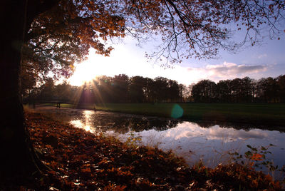 Scenic view of river against sky at sunset