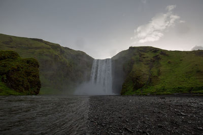 Scenic view of waterfall against sky