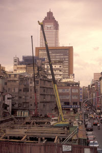 Construction site by buildings against sky