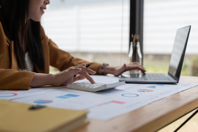 Midsection of businessman working on table