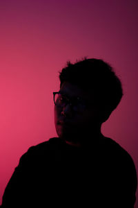 Portrait of young man against pink background