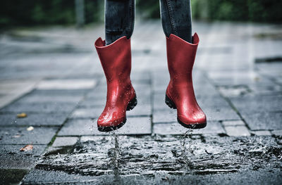 Low section of person standing on wet footpath