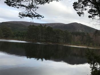 Scenic view of lake by mountains against sky