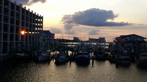 Boats in harbor at sunset