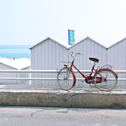 Bicycle by sea against clear sky