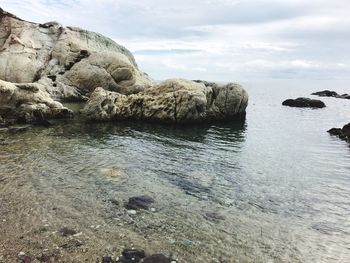 Rock formations in sea against sky