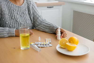 High angle view of woman with pills on table