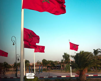 Red flag flags on built structure against sky