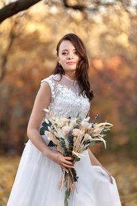 Portrait of smiling young woman holding bouquet
