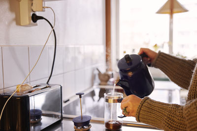 Woman preparing coffee in kitchen