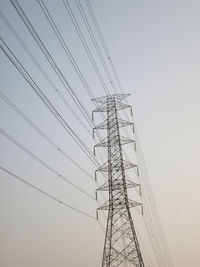 Low angle view of electricity pylon against clear sky