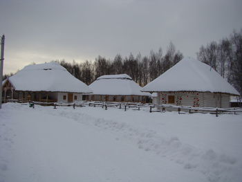 White house on snow covered landscape against sky