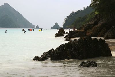 Scenic view of rocks in sea against sky