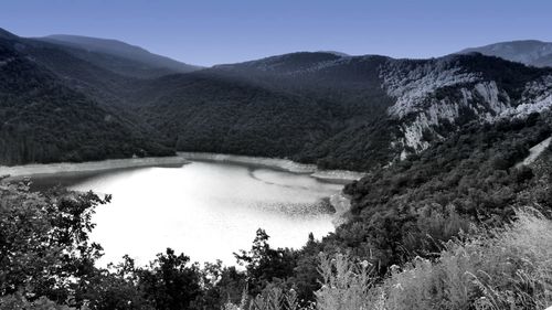 Scenic view of lake and mountains against clear sky