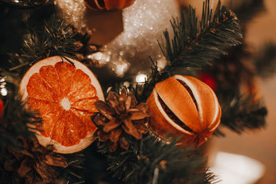 Creative christmas tree decorated with dry oranges, pine cones. magic cozy details, winter season