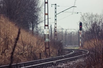 Railway tracks amidst trees against clear sky