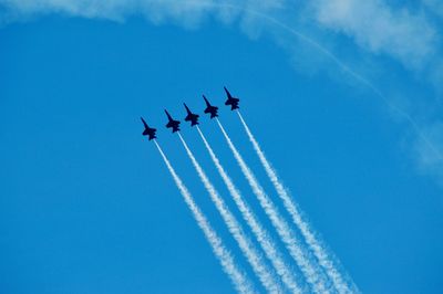 Low angle view of airplane flying against blue sky