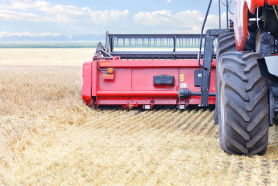 Fragment of a large combine harvester harvesting wheat on a summer day.