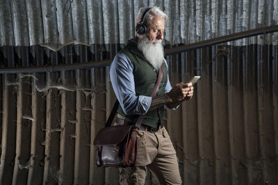 Man looking at camera while standing against wall