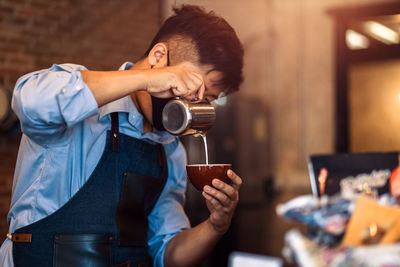 Midsection of man holding coffee cup