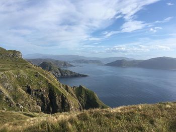 Scenic view of sea and mountains against sky