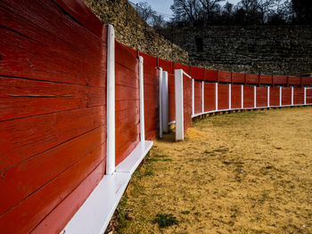 Footpath by red wall against sky