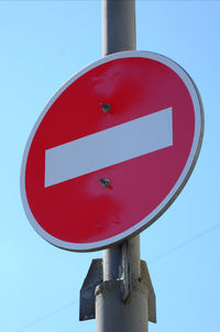 Low angle view of stop sign against clear blue sky