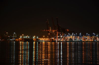 Illuminated commercial dock against sky at night
