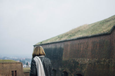 Rear view of woman standing against clear sky