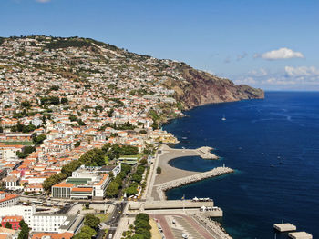 High angle view of townscape by sea against sky